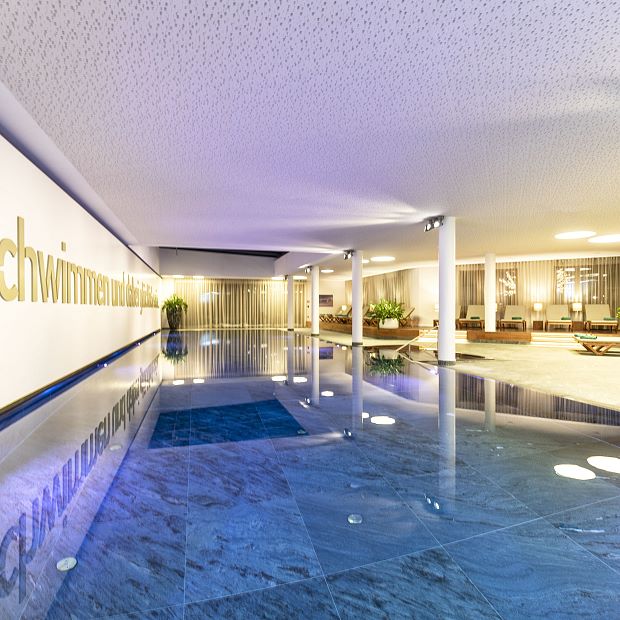 25-Meter-Natursteinpool mit großzügiger Panoramaglaswand